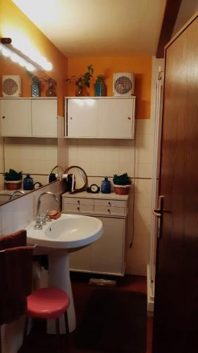 a bathroom with a white sink and a red stool at Borgo Vecchio in Carbognano