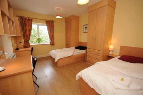 una camera d'albergo con 2 letti e una scrivania di Gort Na Coiribe Holiday Village a Galway