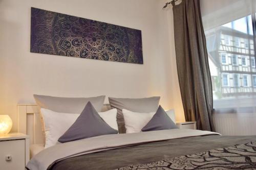 a bedroom with a bed with pillows and a window at Im kleinen Stil ll in Linz am Rhein