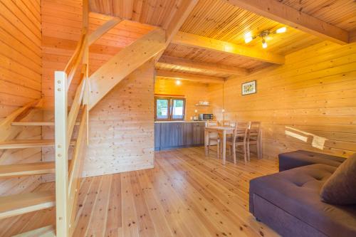 una sala de estar con una escalera en una cabaña de madera en Osada nad Dziwną domki nad morzem, en Dziwnów
