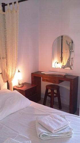 a bedroom with a bed and a desk with a mirror at Giannakas Studios in Platis Yialos Sifnos