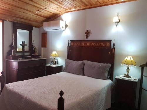 1 dormitorio con 1 cama grande y lavamanos en A Casinha do Beco, en Gouveia
