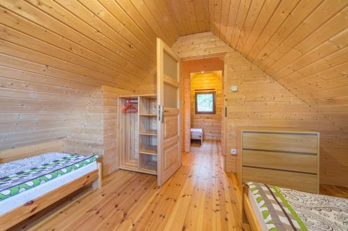 a log cabin with two beds in a room at Osada nad Dziwną domki nad morzem in Dziwnów