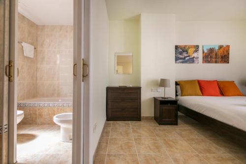 a bedroom with a bed and a bathroom with a tub at Be Barcelona Eixample Urquinaona II in Barcelona