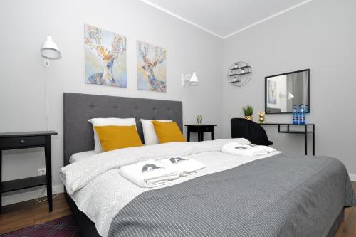 1 dormitorio con 1 cama grande y 2 toallas. en Apartament RESORT Chełmońskiego Śrem, en Śrem