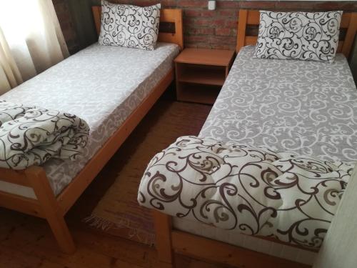 two beds sitting next to each other in a room at Apartmani DiO in Niš