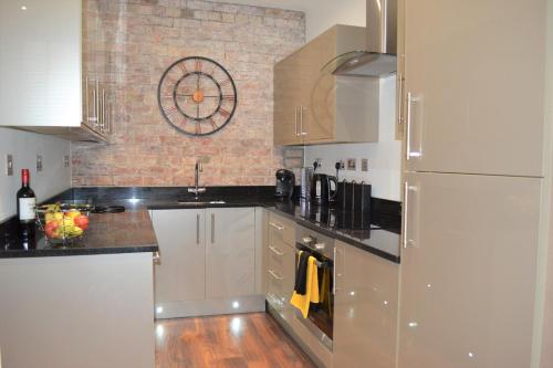 a kitchen with white appliances and a brick wall at OnPoint - 2 Bed Apartment City Centre Ideal Location! in Nottingham