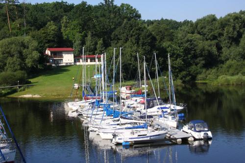 a group of boats docked at a dock in the water at Yacht club Barrandov in Kožlí u Orlíka