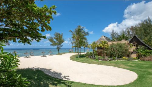 a house on the beach next to the ocean at Shanti Maurice Resort & Spa in Bel Ombre