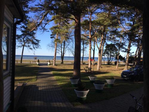 a walkway next to a beach with trees and a building at EFS Höllviksstrand in Höllviken