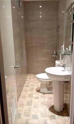 a bathroom with a sink and a toilet and a shower at 市居 民宿 in Yuli