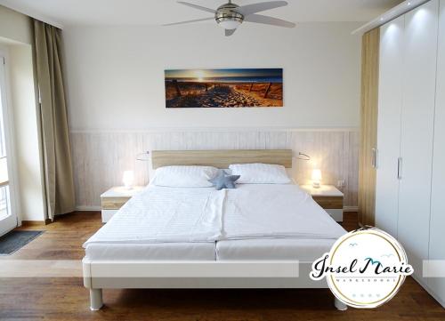1 dormitorio con 1 cama blanca y 2 mesitas de noche en INSELMARIE Wangerooge en Wangerooge