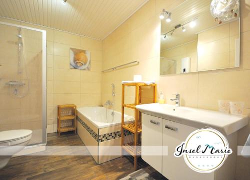 La salle de bains est pourvue d'une baignoire, d'un lavabo et de toilettes. dans l'établissement INSELMARIE Wangerooge, à Wangerooge