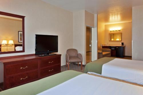 a hotel room with two beds and a flat screen tv at Holiday Inn Express Hotel and Suites - Henderson by IHG in Las Vegas