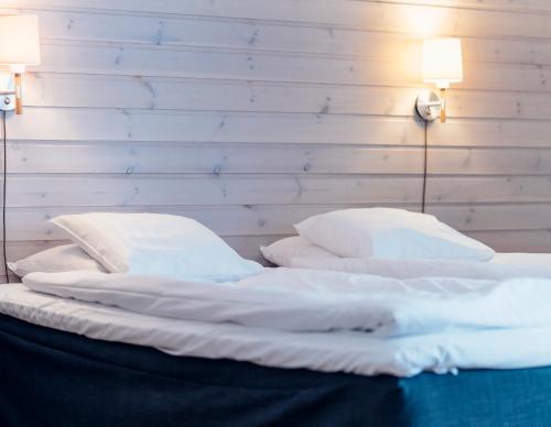 two beds with white sheets and pillows in a room at Pernilla Wiberg Hotel in Idre
