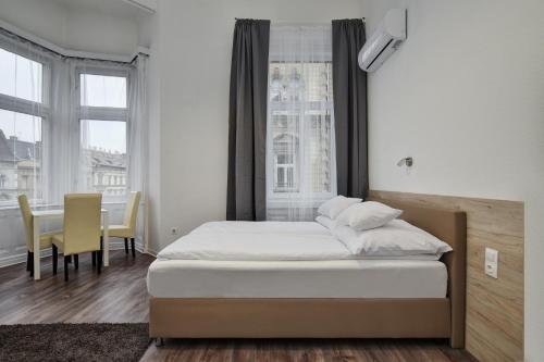 Un dormitorio con una cama y una mesa y sillas. en Heart of Downtown Apartment, en Budapest