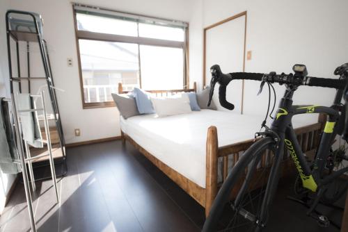 a bike is parked next to a bed in a room at 南紀くまのいえ-WAKAYAMA・古座- in Kushimoto