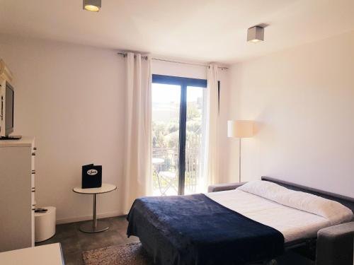 a bedroom with a bed and a large window at En Aparté in Porto-Vecchio