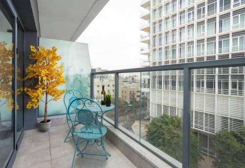 a balcony with a table and chairs and a window at Spacious 3BR Penthouse with Jacuzzi on Rosthchild by HolyGuest in Tel Aviv