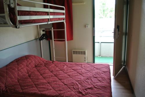 a bedroom with a bunk bed with a pink comforter at Premiere Classe Lyon Sud - Chasse Sur Rhône in Chasse-sur-Rhône