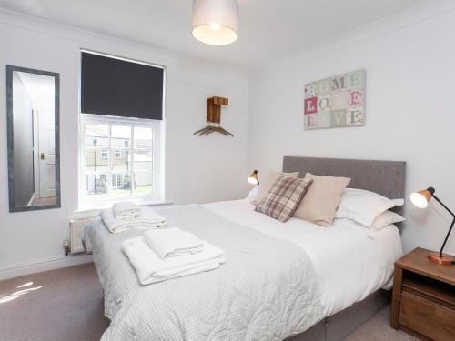a bedroom with a white bed with two towels on it at Fountains view Apartment in York