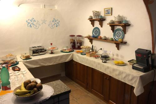 una cucina con due ripiani con del cibo sopra di Villa Dessena Guest House a Cala Liberotto