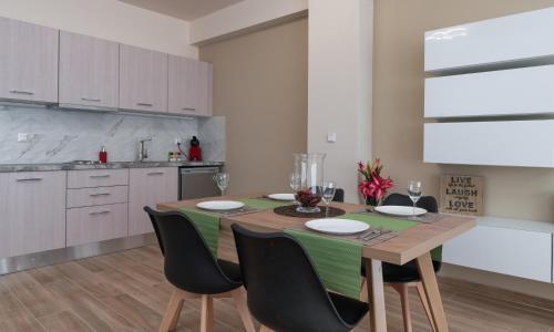 a kitchen with a wooden table and black chairs at Amazing Apartments @ Monastiraki Subway Station in Athens
