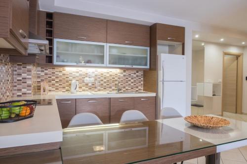 a kitchen with wooden cabinets and a white refrigerator at Katia Appartment in Agios Nikolaos