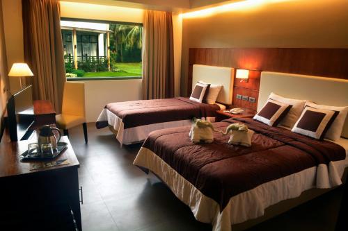 a hotel room with two beds and a window at Ariana Hotel in Dipolog