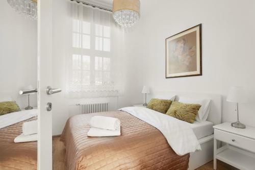 a white bedroom with two beds and a window at VIU Postcards from Gdansk in Gdańsk
