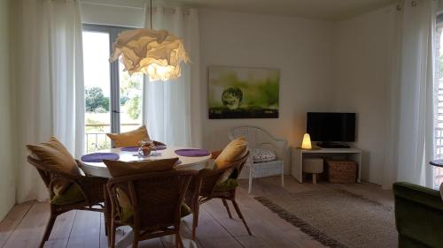 ein Esszimmer mit einem Tisch, Stühlen und einem TV in der Unterkunft Landhaus Sinneswandel in Nauen