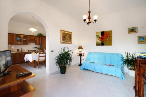 salon z niebieską kanapą i stołem w obiekcie Appartamenti Villa Chiara w mieście Imperia