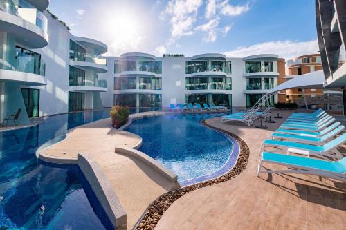 a large swimming pool in front of a large building at Absolute Twin Sands Resort & Spa - SHA Extra Plus in Patong Beach