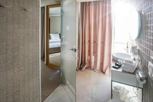 a bathroom with a sink and a toilet and a mirror at Jump INN Hotel Belgrade in Belgrade