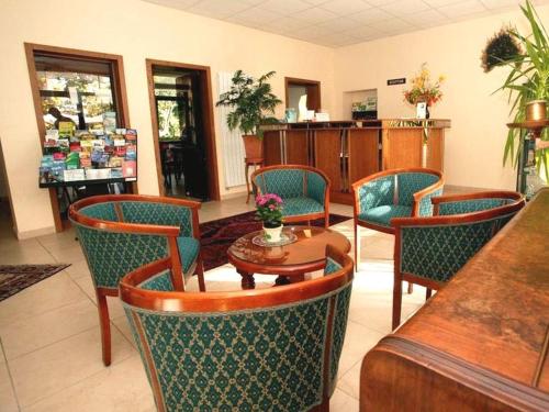 a restaurant with chairs and a table and a counter at Hotel Union in Sarreguemines