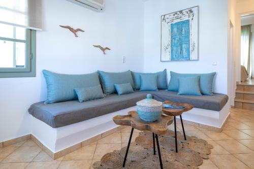 a couch in a living room with blue pillows at Mirabeli Apartments & Suites in Pollonia