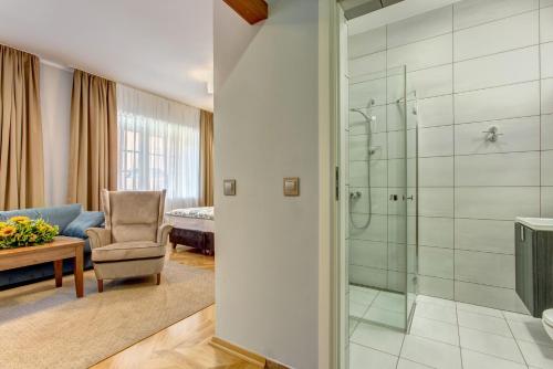 a bathroom with a shower and a chair in a room at Hotel Książ in Wałbrzych