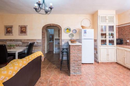 a kitchen with a refrigerator and a table in a room at Casas Guemon in Zahora