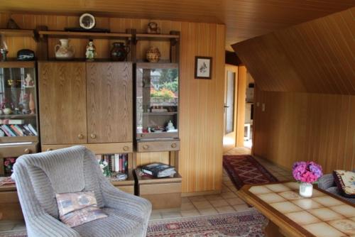 Friedeburg的住宿－Ruhige Unterkunft nahe der Nordsee，客厅配有椅子和桌子