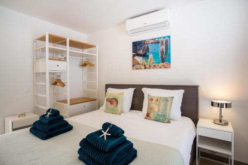 sypialnia z 2 niebieskimi ręcznikami na łóżku w obiekcie La Vista Luxury Apartment Jan Thiel w mieście Jan Thiel