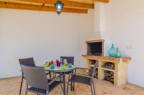 a dining room with a table and chairs and a fireplace at Can Pistola in Algaida