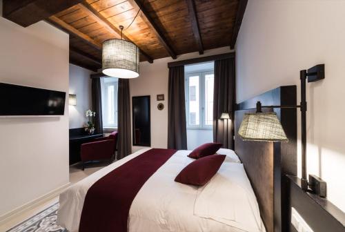 sypialnia z dużym łóżkiem z czerwonymi poduszkami w obiekcie Dolcevita Apartments w Rzymie