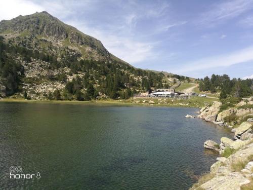 a body of water with a mountain in the background at Tarter Confort Hut 5065 in El Tarter