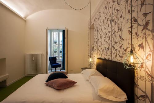 1 dormitorio con 1 cama con 2 almohadas en Le Tre Madame, en Turín