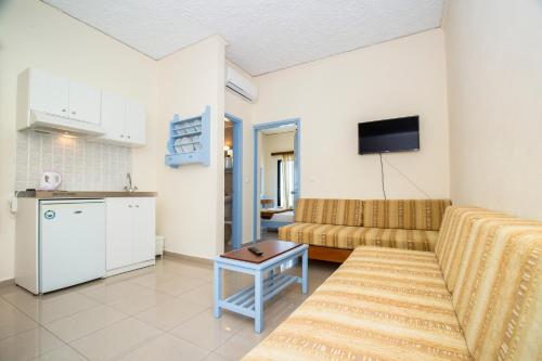 un soggiorno con un divano e una TV di Mandy Suites a Kíssamos