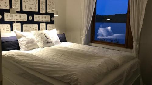 a bedroom with a large white bed with a window at Galasjön 132 in Mellansel