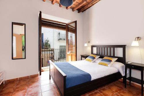 ein Schlafzimmer mit großem Bett und Balkon in der Unterkunft Urban Suites Granada in Granada