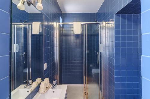 ポルトにあるリンド ヴェイル ゲストハウスの青いタイル張りのバスルーム(シンク2台、シャワー付)