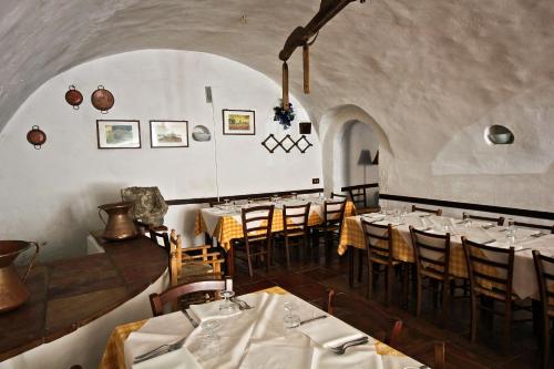 une salle à manger avec des tables, des chaises et un tissu de table blanc dans l'établissement Il Cantinone Rooms, à Castelnuovo di Farfa