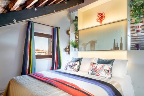 een slaapkamer met een bed met kleurrijke kussens bij PgrHome Coral Loft Venice in Venetië
